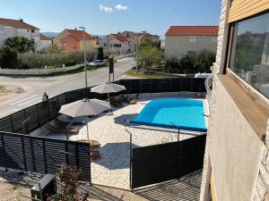 a swimming pool with umbrellas and chairs and a swimming pool at Villa Feodora in Biograd na Moru