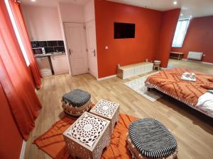 a bedroom with two beds and two ottomans at Studio Chic N2 avec Jacuzzi in Roubaix