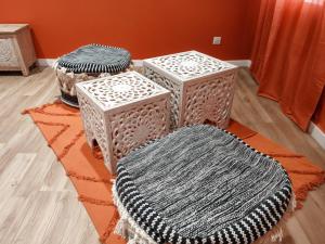 a room with two tables and two cushions on a rug at Studio Chic N2 avec Jacuzzi in Roubaix