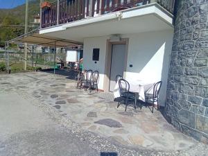 a patio with chairs and a table on a building at Cà Negra Ca negra suite in Costa Volpino