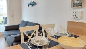 a living room with a table and a blue couch at Baabe Villen-Ensemble FeWo 41 Muschelsucher in Baabe