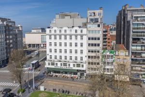 een wit gebouw in een stad met hoge gebouwen bij Maison Anna by Exclusive-Stays in Oostende