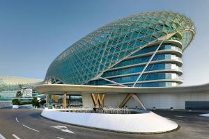 a large building with a curved roof in a parking lot at W Abu Dhabi - Yas Island in Abu Dhabi