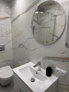 a white bathroom with a sink and a mirror at APARTAMENT KASZMIR w KRÓLEWSKIM SANDOMIERZU in Sandomierz +55 photos