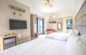 a bedroom with two beds and a flat screen tv at 綠道74民宿Green Lane 74 in Hualien City