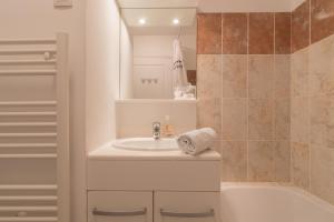 a white bathroom with a sink and a tub at Le Colombe - Centre de La Baule - Wifi in La Baule