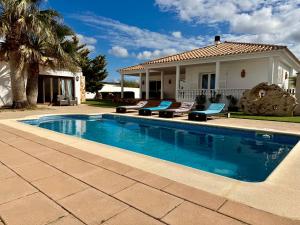 a swimming pool in front of a house at Villa Coral in Cala en Blanes