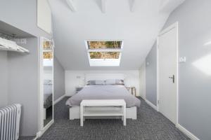 a white bedroom with a bed and a table at Cottage 315 - Clifden in Clifden