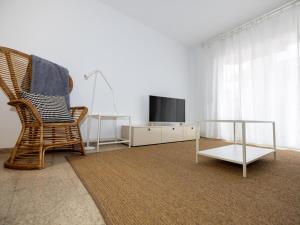 a living room with a chair and a television at Winahost Apartmento Sant Feliu de Guíxols in Sant Feliu de Guixols