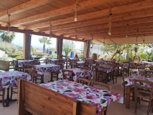 a restaurant with tables and chairs with flowers on them at agriturismo heaven in Capo Vaticano