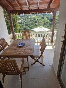 a wooden table and chairs on a balcony at Sevinc Papatya House in Milas +44 photos