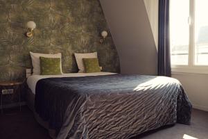 a bedroom with a large bed with a black blanket at Hôtel Azur in Reims
