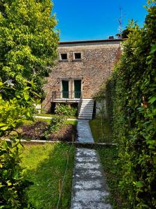 a stone path leading to a building with a balcony at Appartamenti Picedo in Polpenazze del Garda