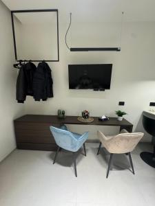 ナポリにあるCris Apartmentsの椅子2脚とテーブルのあるリビングルーム +4枚の写真