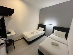 una camera con due letti e una TV a schermo piatto di Self Check-In - Havona Hotel Plentong a Johor Bahru