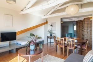 a living room with a table and chairs and a television at Aparthotel Oporto Alves da Veiga in Porto