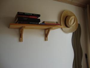 a shelf with books and a hat on a wall at MER à pied STUDIO Vrai Lit LINGE FOURNI Jardin VÉLOS BIENVENUS in Bretignolles-sur-Mer