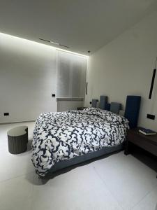 Un dormitorio con una cama con un edredón blanco y negro. en Holiday Home 63, en Nápoles