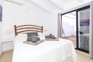 a bedroom with a white bed with towels on it at Precioso Atico Sa Perdiu in Cala Santandria +15 photos