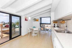 a kitchen and dining room with a table and chairs at Precioso Atico Sa Perdiu in Cala Santandria