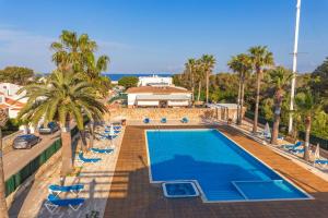 an overhead view of a swimming pool with palm trees and chairs at Precioso Atico Sa Perdiu in Cala Santandria