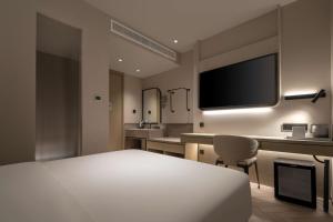 a hotel room with a bed and a television at The Yume Hotel in Nanjing