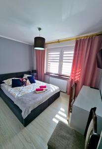 a bedroom with a large bed with pink curtains at Jagiellończyk in Sulejów