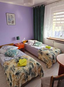 a bedroom with two beds and a table and a window at Jagiellończyk in Sulejów