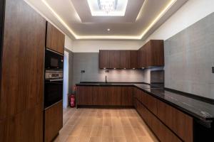 a large kitchen with wooden cabinets and a ceiling at Novaotel Malaga in Málaga