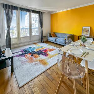 una sala de estar con una mesa y un sofá en Balcon, Fibre rapide & Parking, en Neuilly-sur-Marne
