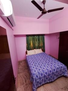 a purple bedroom with a ceiling fan and a bed at La Vonto - Madurai Railway Junction in Madurai