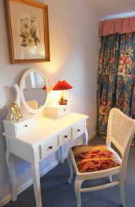 a white dressing table with a mirror and a chair at Das Bärenhaus in Bergen