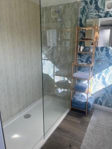 a shower with a glass door and some towels at The Snuggery Broadclyst in Exeter +23 photos