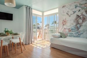 ein Wohnzimmer mit einem Sofa und einem Tisch mit einem Schreibtisch in der Unterkunft Nura Houses Magaluf Beach - Superior Apt in Magaluf