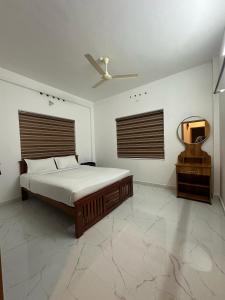 um quarto com uma cama e um espelho na parede em Heaven Meadows Homestay Vagamon em Vagamon