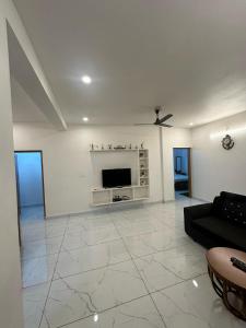 uma sala de estar com um sofá preto e uma TV em Heaven Meadows Homestay Vagamon em Vagamon