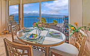 a table on a balcony with a view of the ocean at Royal Kahana 610 in Kahana