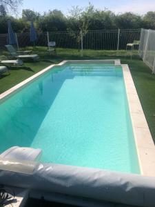 a large swimming pool with blue water in a yard at Maison de Vacances Cronat - Au Bord de l'EuroVelo 6 in Cronat