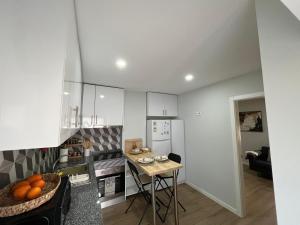 a kitchen with white cabinets and a table with oranges on it at Cantinho das Quintãs in Viseu