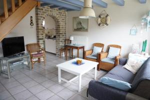 a living room with a couch and a table at Kustverhuur, Nieuwesluisweg 6A in Breskens