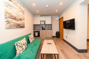 a living room with a green couch and a table at Bloomsaway Seafront Two Bedroom BN112SHP03 in Brighton & Hove