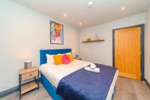 a bedroom with a blue and white bed and a wooden door at Bloomsaway Seafront Two Bedroom BN112SHP03 in Brighton & Hove