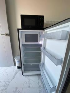 an empty refrigerator with a microwave inside of it at Guest Room Bang Tao MMA in Ban Thalat Choeng Thale