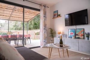 a living room with a couch and a tv and a table at La Casa Garriga - Pont du Gard - Nîmes in Lédenon