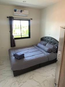 a large bed in a bedroom with a window at Guest Room Bang Tao MMA in Ban Thalat Choeng Thale