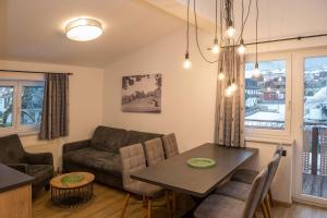 a living room with a table and a couch at Elto Appartements in Kaprun