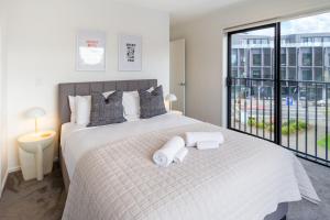 Un dormitorio con una cama grande con toallas. en Urban Comfort on Durham St, Walk Everywhere!, en Christchurch