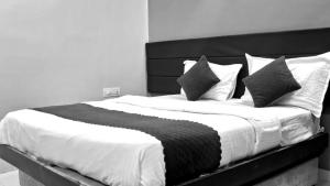奥兰加巴德Hotel Rajlaxmi Executive的一张大床，配有黑白床单和枕头