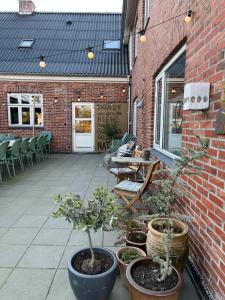 a patio with potted plants on a brick building at Gæstehusets lejlighed in Tarm