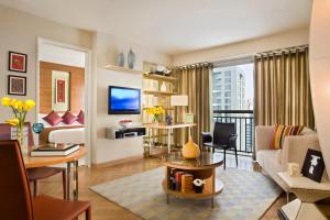a living room with a couch and a tv at Ascott Guangzhou, Free Shuttle Bus For Canton Fair in Guangzhou